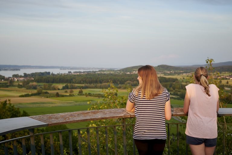 Zwei Frauen schauen auf der Blattform auf dem Galgenberg in Bohlingen über die Hegaulandschaftm